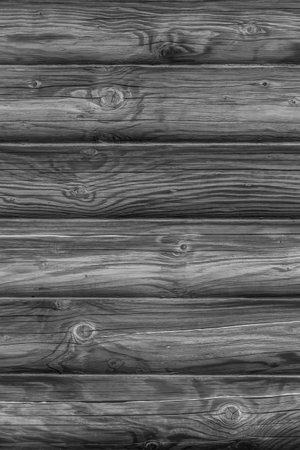 black and white photo of dark wooden wall made of logsの写真素材