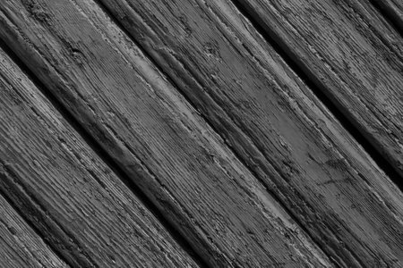 black an white photo of old painted wooden fence made of diagonal planksの写真素材
