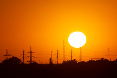 view on sun behind electrical poles in Ukraine at sunset