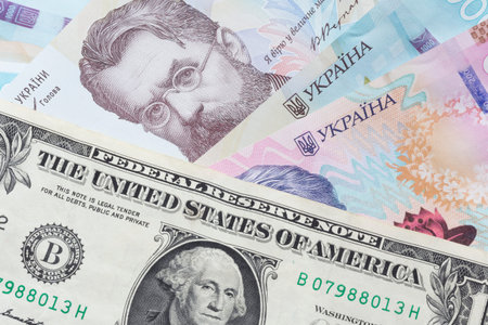 close up of one United States dollar banknote lying on Ukrainian hrivnya banknotes