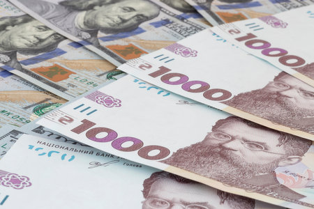 close up of several one thousand Ukrainian hrivnya banknotes lying on US dollars banknotesの写真素材