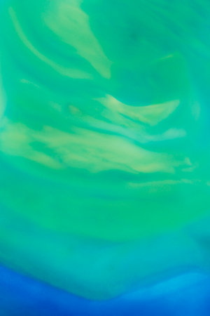 abstract background: liquid mix of blue, green and yellow paintsの写真素材