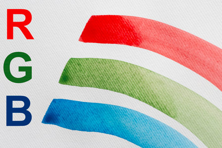 RGB color concept: red, green and blue letters and watercolor strokes on white paperの写真素材