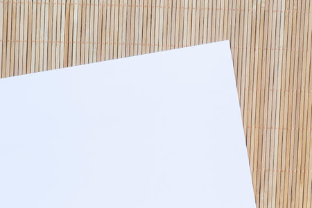 close up of blank sheet of paper laying on bamboo matの写真素材