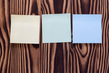 close up of three blank color notes sticked to wooden memory board