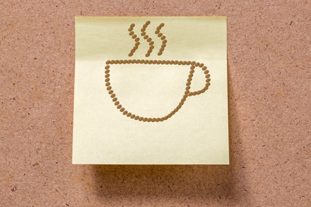 hot cup of coffee drawn with coffee beans on memory note sticked to boardの写真素材