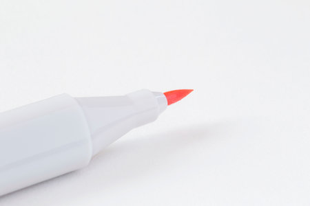 close up of opened orange marker lying on blank page of  sketch bookの写真素材