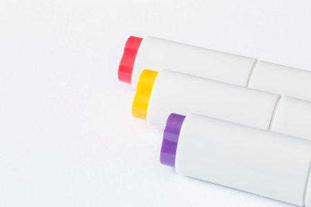 close up of three sketching markers lying on blank white page of sketch book