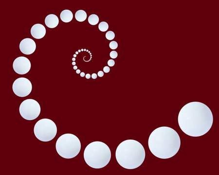 elegant spiral made of white agate beads against dark red backgroundの写真素材