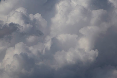 close up of dark and light fluffy rain clouds in a skyの写真素材