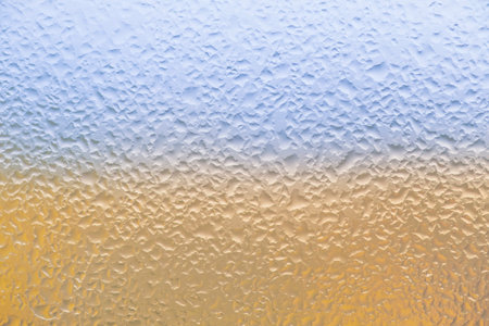 wet window colored in colors of Ukrainian flagの写真素材