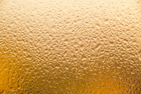 abstract backdrop: close up of wet window colored in goldenの写真素材