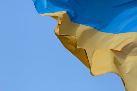 close up of waved Ukrainian flag against clear blue skyの写真素材