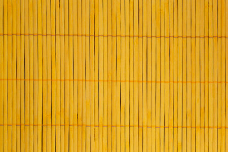 abstract background: close up of yellow mat made of bamboo sticksの写真素材