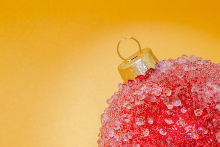 close up of red Christmas tree ball against golden backdropの写真素材
