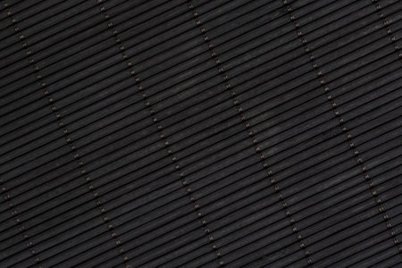 abstract background: close up of black bamboo mat made of thin planksの写真素材