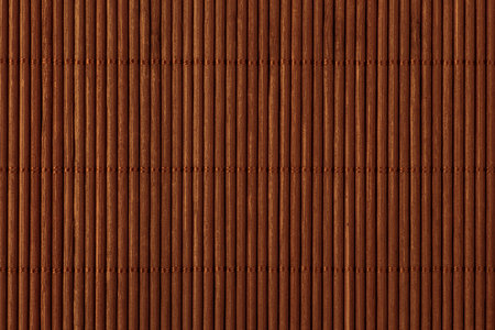 abstract background: close up of kitchen mat made of brown bamboo sticksの写真素材