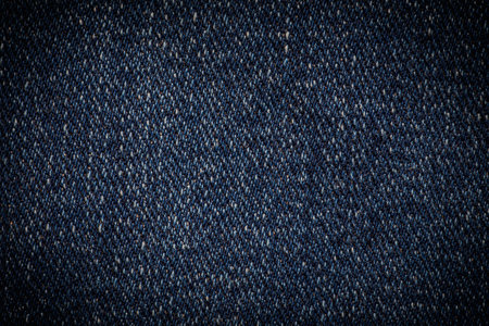 abstract background: close up of dark blue denim texture with shadowed edgesの写真素材