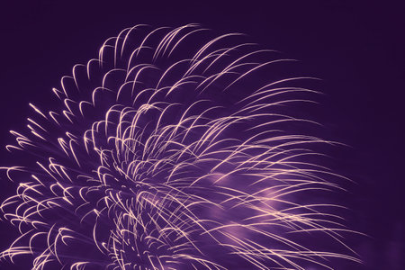 abstract holiday card backdrop: yellow color fireworks in dark violet night skyの写真素材