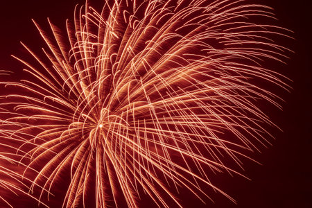 abstract holiday card background: bright fireworks in dark red night skyの写真素材
