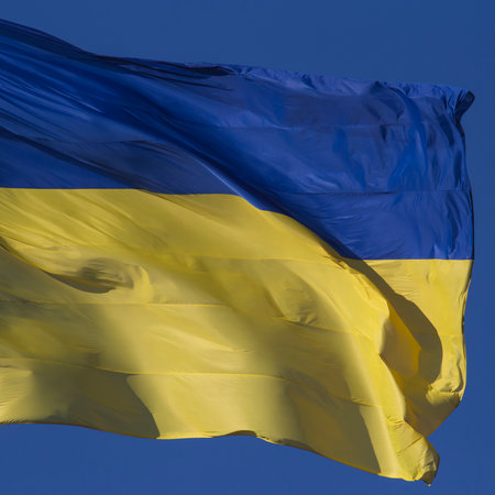 square card with closeup of waved flag of Ukraine against blue skyの写真素材