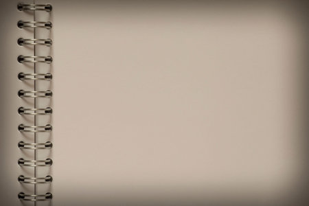 abstract backdrop with shadowed edge: close up of blank page of notepad with spiral binder