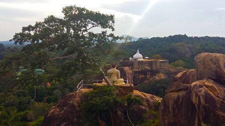 Beautiful sunset over buddha temple on the rockの写真素材