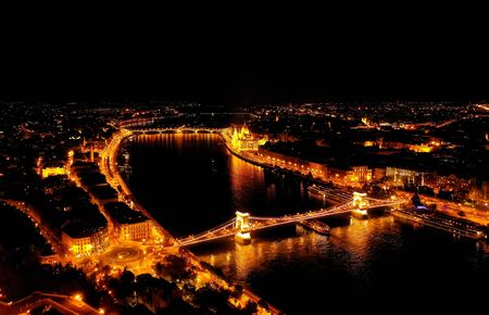 Beautiful night view of the old city of Budapest from a height, shot on a drone. In the middle of the Danube river and chain bridge. Panarama night view.の写真素材