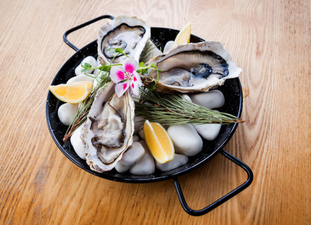 Fresh oysters on a plate with ice and flowers. Restaurant