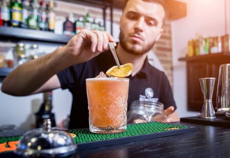 Bartender is making non alcoholic cocktail at bar counter. Fresh cocktails. Barman at work. Restaurant. Nightlife.の写真素材