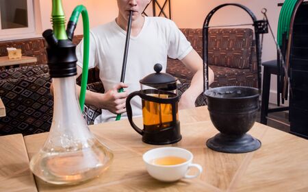Cooking hookah in the bar. Young man with hookah in restaurant, hookah bar, smoking cafe.の写真素材