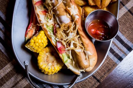 Hotdog and French fries on a dish. Fast food meal. Restaurant.の写真素材