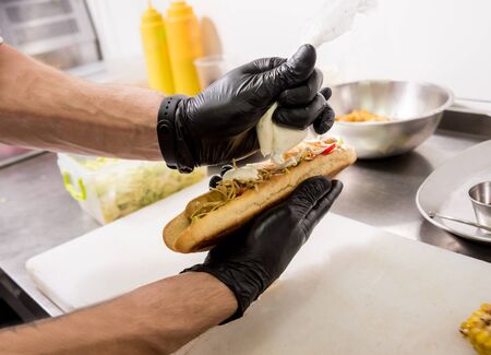 The chef cooking hot dog on a grill. Restaurant.の写真素材
