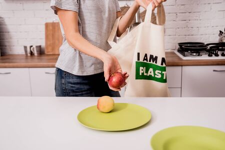 Young girl holding a cloth bag. At the kitchen. I am not plastic. Campaign to reduce the use of plastic bags. Zero wasteの写真素材