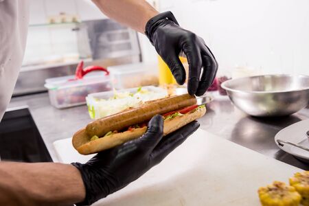 The chef cooking hot dog on a grill. Restaurant.の写真素材