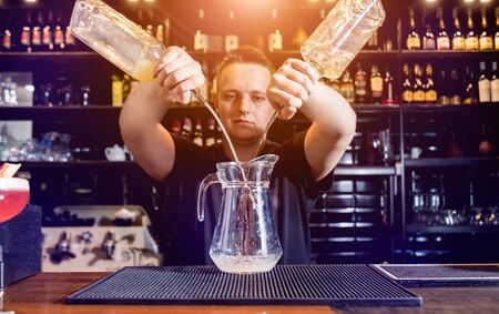 Bartender is making cocktail at bar counter. Fresh cocktails. Barman at work.の写真素材
