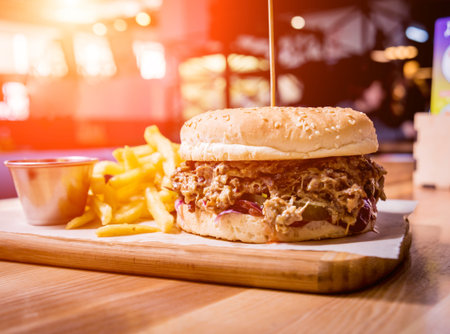 Tasty cheeseburger and chips on the wooden table. Restaurant.
