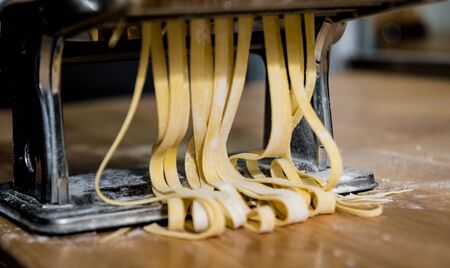 Chef rolling dough with a pasta machine. Pasta maker machine.の写真素材