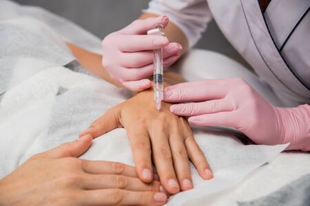 The doctor cosmetologist makes the arms injections procedure.の写真素材