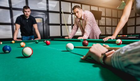 Young man trying to hit the ball in billiard.の写真素材