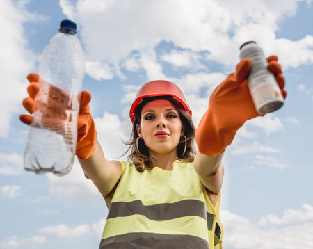 Woman volunteer helps clean the field of plastic garbage.