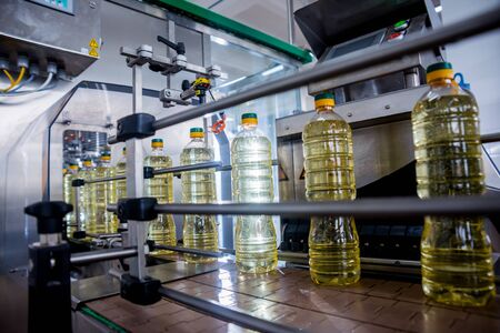 Bottling line of sunflower oil in bottles. Vegetable oil production plant. High technology. Industrial backgroundの写真素材