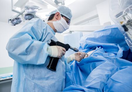 Arthroscope surgery. Orthopedic surgeons in teamwork in the operating room with modern arthroscopic tools. Hospital backgroundの写真素材