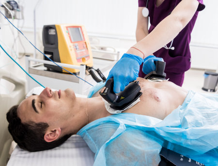 Doctors give resuscitation to a male patient in the emergency room. Cardiac massage. Defibrillation