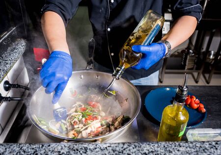 Chef cooking pasta with vegetables in pan. Italian style cuisine. Restaurant. Backgroundの写真素材