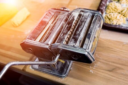 Chef rolling dough with a pasta machine. Pasta maker machine.の写真素材