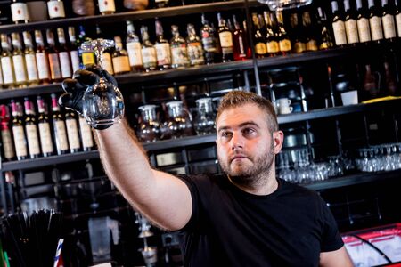 The bartender wipes the wine glasses in the bar. Restaurant.の写真素材