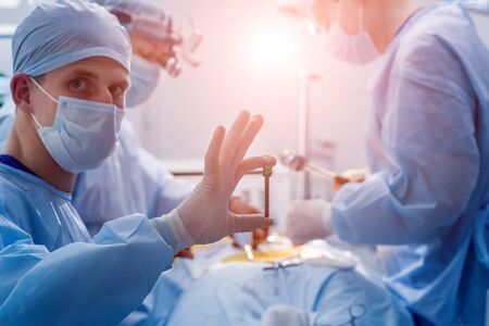 Spinal surgery. Group of surgeons in operating room with surgery equipment. Laminectomy. Modern medical backgroundの写真素材