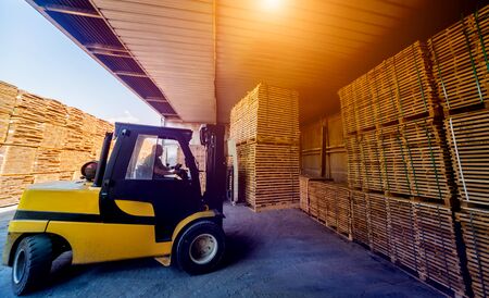 Forklift loader load lumber into a dry kiln. Wood drying in containers. Industrial conceptの写真素材