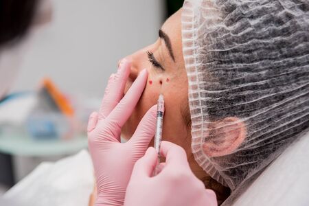 The doctor cosmetologist makes the facial injections procedure.の写真素材